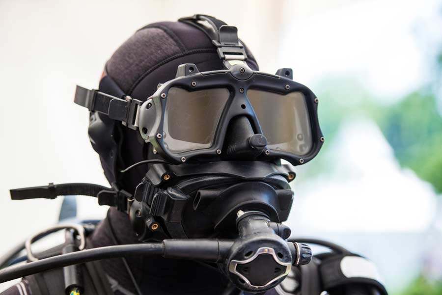 Close-up of a combat diver in a hood wearing a full-face dive mask and regulator